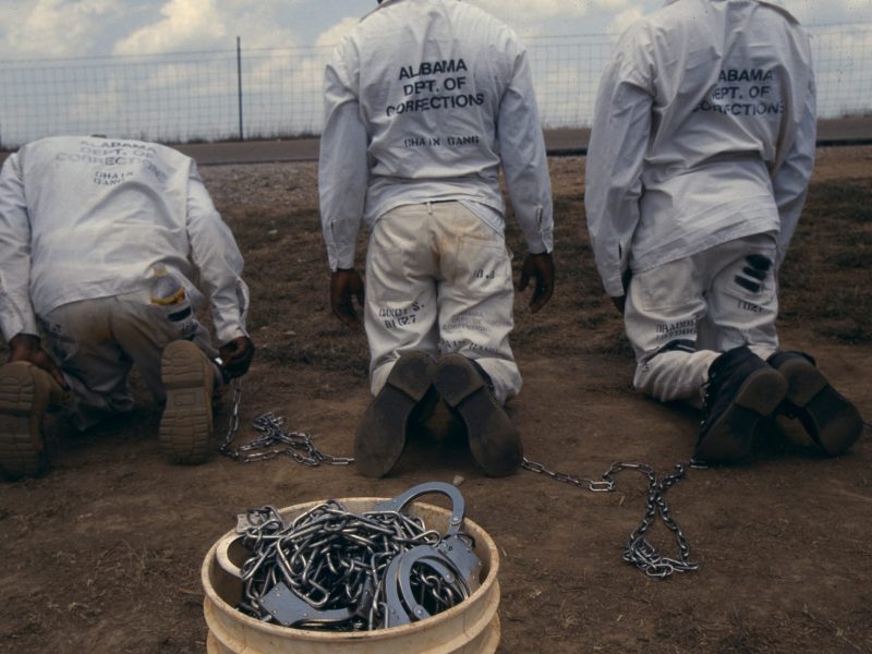 Convicts at the Limestone Correctional facility are placed back onto the chain gang when they leave the prison grounds for their daily labor as road crews in July of 1995 outside of Huntsville, Alabama. Photo by Andrew Lichtenstein/Corbis via Getty Images