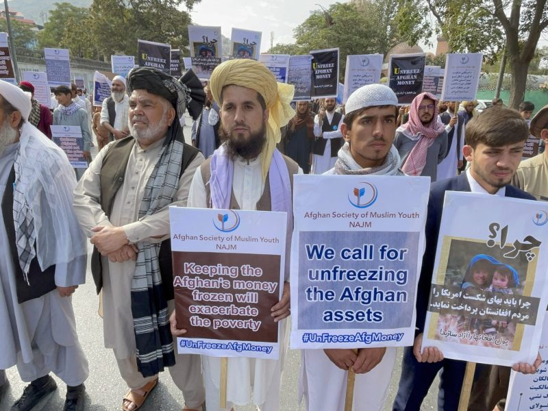 Afghan people stage a protest in demand of the release billions of dollars in central bank reserves blocked by the US