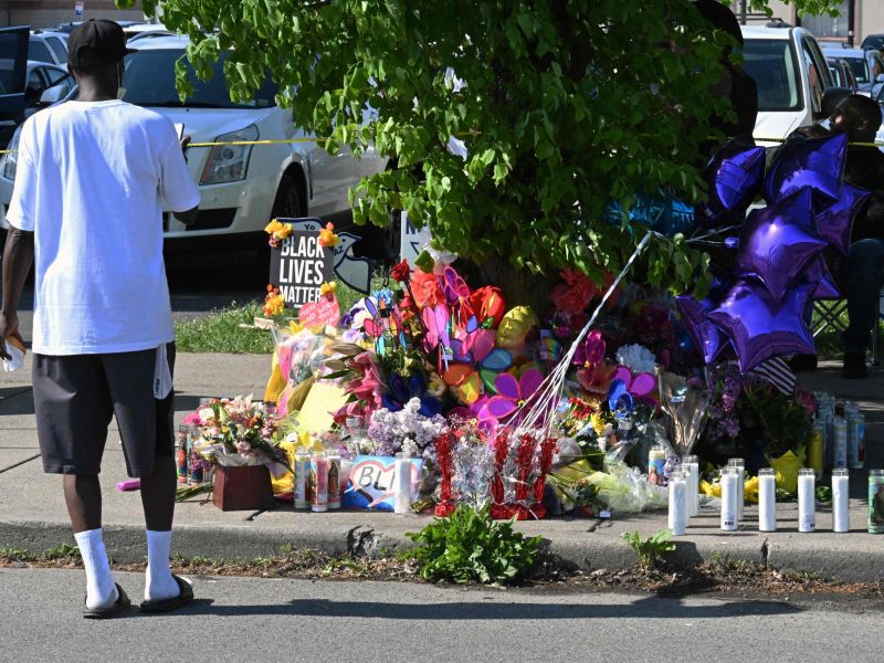 A man takes a picture of a makeshift memorial near a Tops Grocery store in Buffalo, New York, on May 15, 2022, the day after a gunman shot dead 10 people.