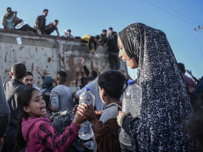 Palestinians flock to a truck carrying drinkable water, as they face the threat of hunger and thirst in Rafah, Gaza on December 11, 2023. ANADOLU / GETTY IMAGES