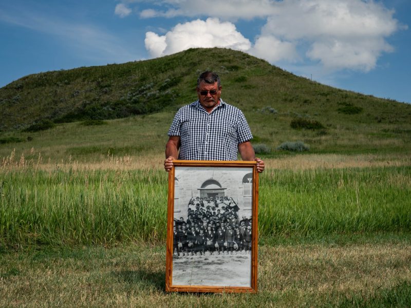 Warren Morin, 59, a member of Gros Ventre and Assiniboine tribes, holds a framed photo of his grandfather and other family members attending St. Paul's Mission boarding school as children on the Fort Belknap Reservation in Lodge Pole, Montana, Wednesday, July 12, 2023. Photo by Salwan Georges/The Washington Post via Getty Images