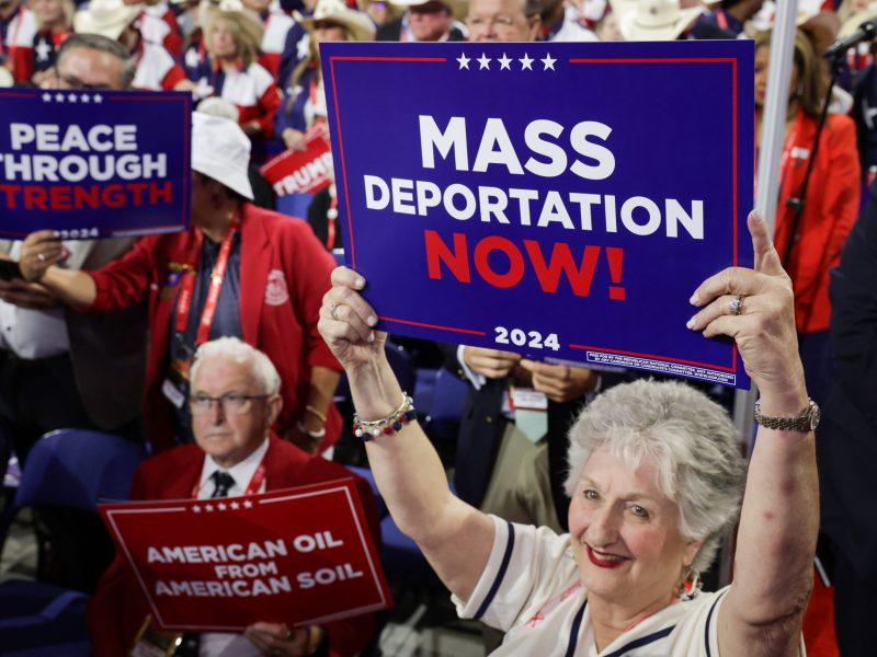 People hold signs that read "Mass Deportation Now!" on the third day of the Republican National Convention at the Fiserv Forum on July 17, 2024 in Milwaukee, Wisconsin. Photo by Alex Wong/Getty Images.