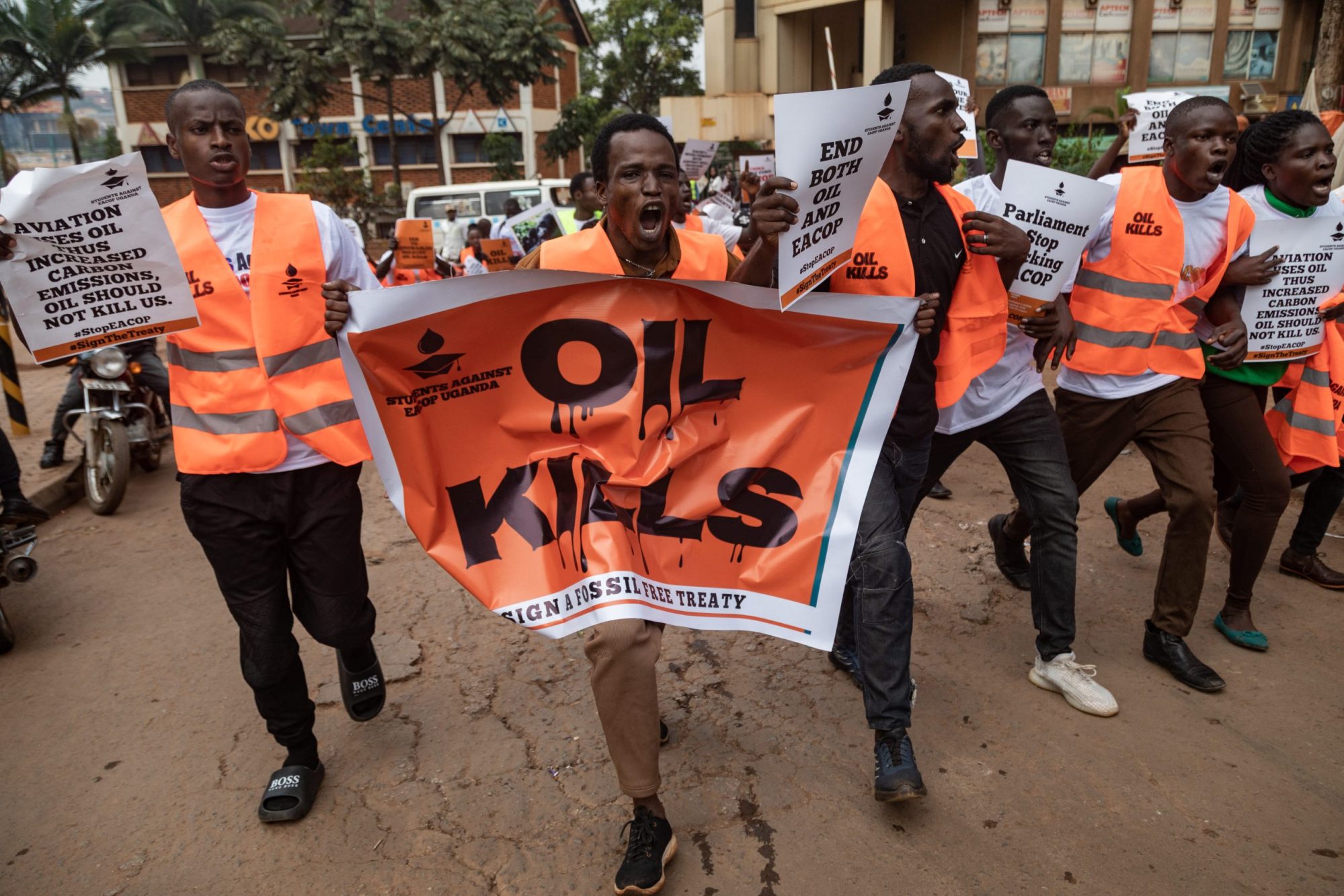 Environmental activists hold banners and chant slogans as they protest against the East African Crude Oil Pipeline Project (EACOP) in Kampala on August 26, 2024. Photo by BADRU KATUMBA/AFP via Getty Images