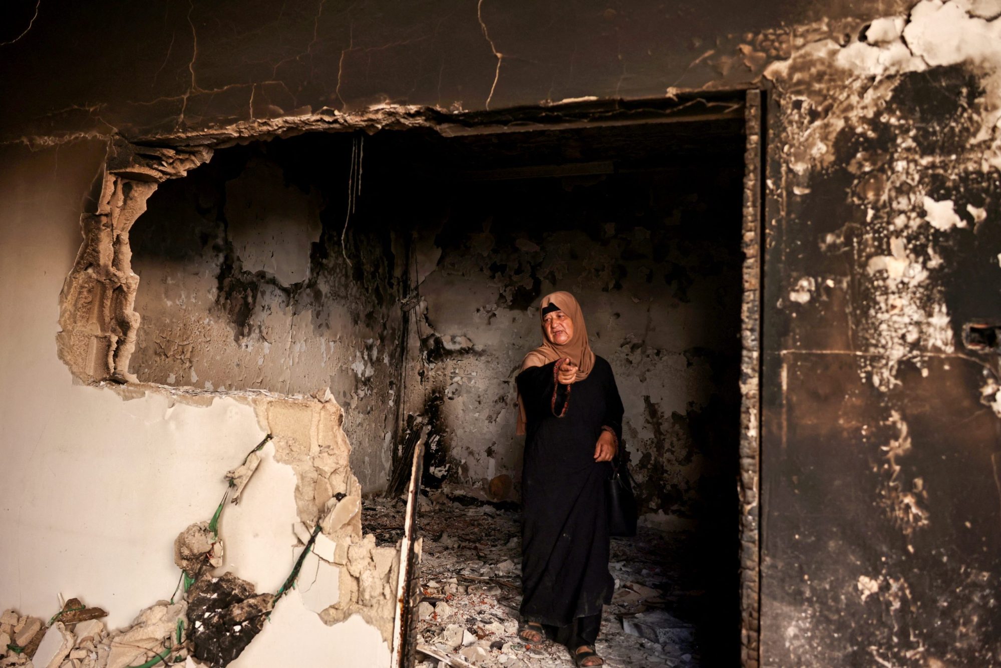 A Palestinian woman points as she stands in a home that was damaged during an Israeli raid the previous day in the Jenin refugee camp in the occupied West Bank on September 26, 2024. Photo by ZAIN JAAFAR/AFP via Getty Images