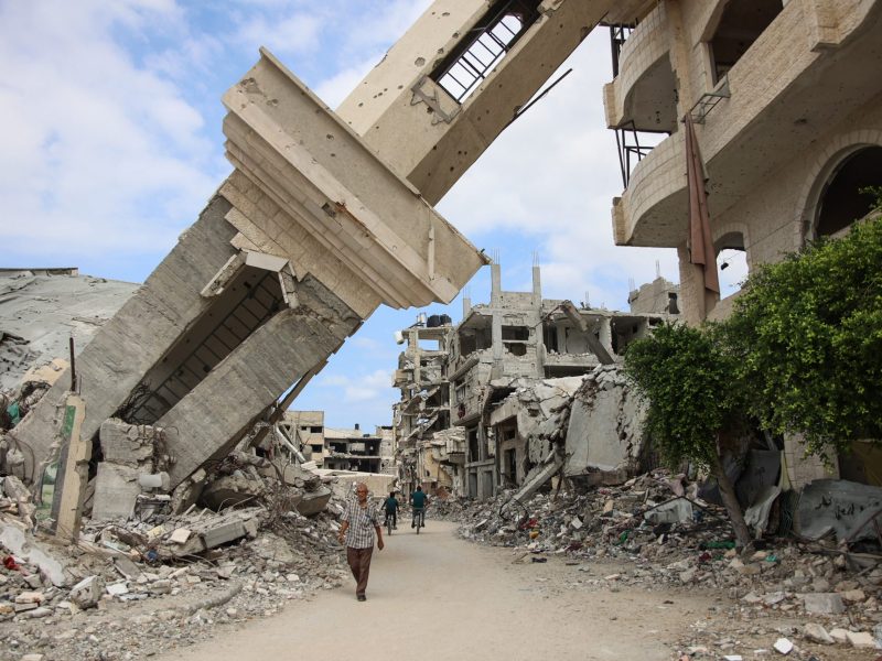 Palestinians walk beneath the tilted minaret of a destroyed mosque in the Shujaiya neighbourhood of Gaza City on October 7, 2024. Photo by OMAR AL-QATTAA/AFP via Getty Images