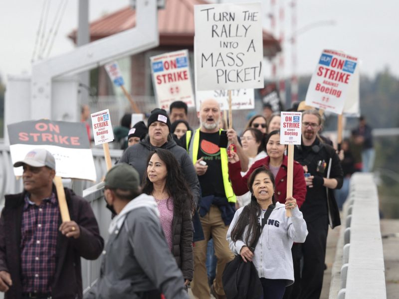 People carry sings as they march towards Boeing Field following a strike rally for the International Association of Machinists and Aerospace Workers (IAM) at the Seattle Union Hall in Seattle, Washington, on October 15, 2024. Photo by JASON REDMOND/AFP via Getty Images