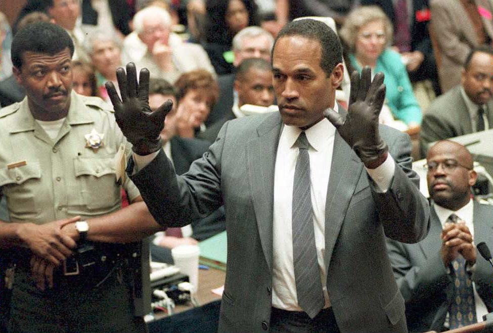 O.J. Simpson shows the jury a new pair of Aris extra-large gloves, similar to the gloves found at the Bundy and Rockingham crime scene 21 June during his double murder trial in Los Angeles. Photo credit should read POO/AFP via Getty Images