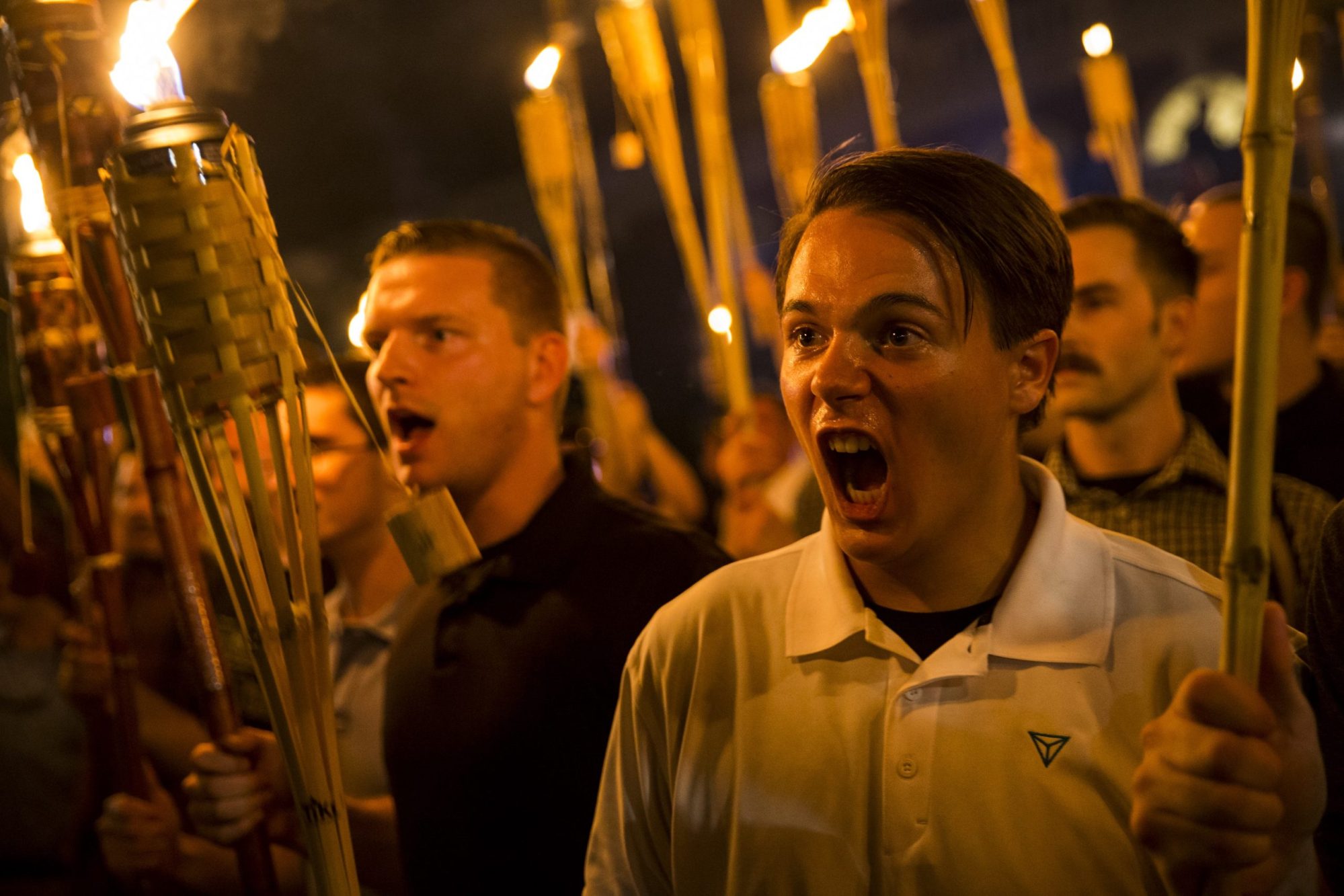 Peter Cvjetanovic (R) along with Neo Nazis, Alt-Right, and White Supremacists encircle and chant at counter protestors at the base of a statue of Thomas Jefferson after marching through the University of Virginia campus with torches in Charlottesville, Virginia., on Aug. 11, 2017.