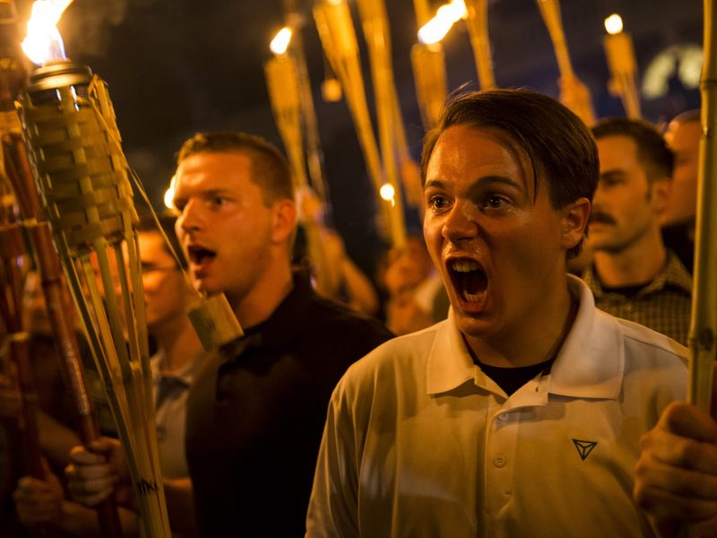 Peter Cvjetanovic (R) along with Neo Nazis, Alt-Right, and White Supremacists encircle and chant at counter protestors at the base of a statue of Thomas Jefferson after marching through the University of Virginia campus with torches in Charlottesville, Virginia., on Aug. 11, 2017.