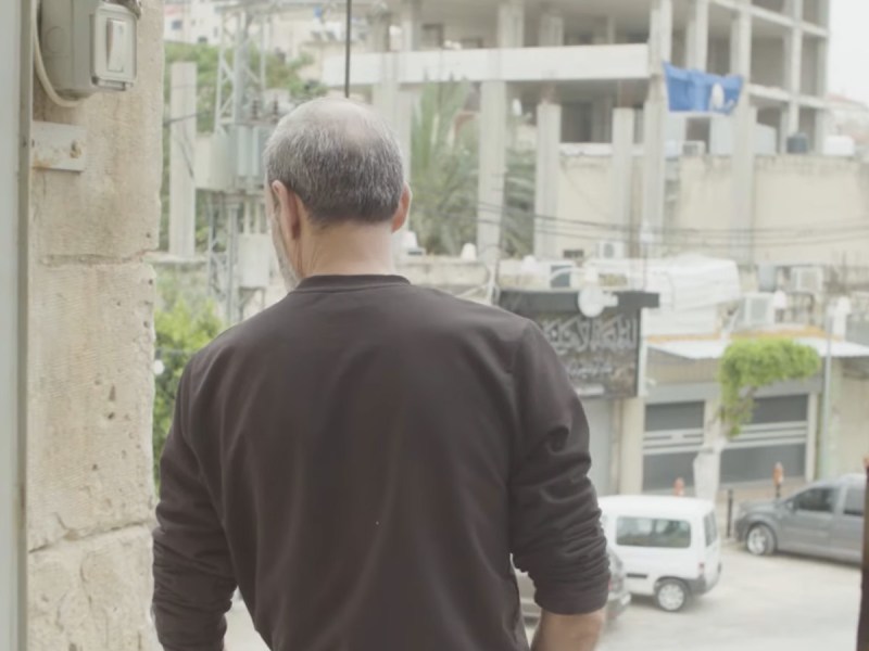 A Palestinian worker from the Gaza Strip looks out into the street in Tulkarm, West Bank. Screenshot from video by Ross Domoney