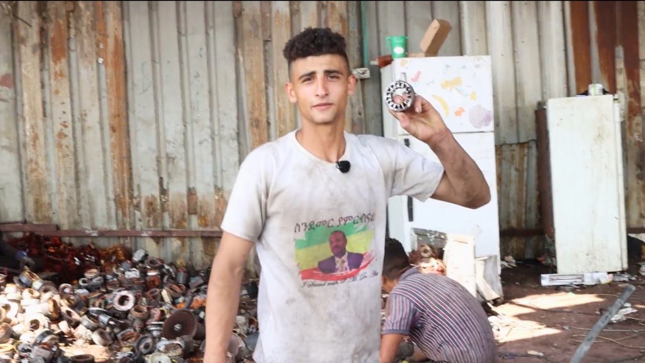 A worker at an e-waste recycling factory in Idhna, West Bank, shows a piece of electronic waste. Screenshot taken from video by Ahmad Al-Bazz