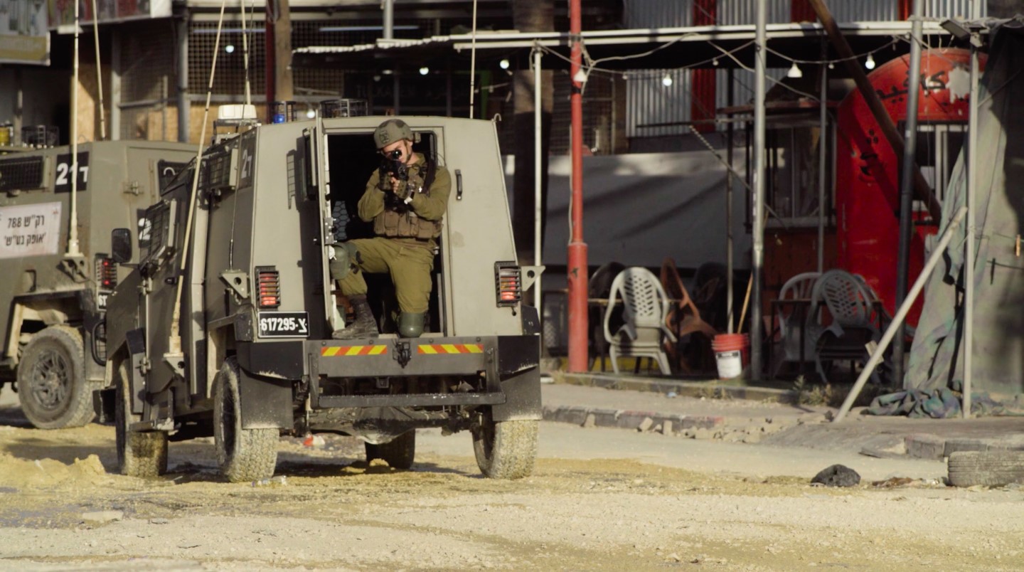 An IDF soldier trains his weapon at the camera during a raid on Nur Shams, West Bank, on April 18, 2024.