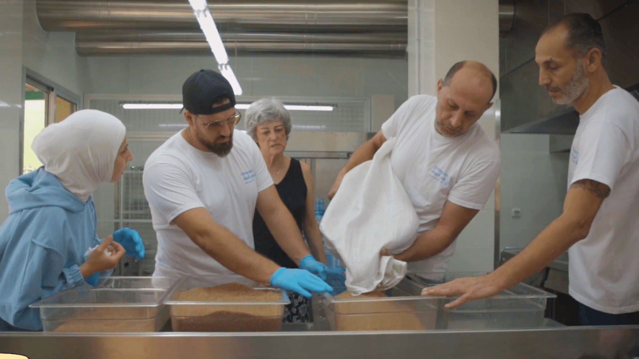 Volunteers at the Beit Aam Community Space in Beirut prepare meals in the community kitchen. Frame taken from video by XXX